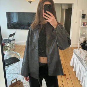 Brun läderjacka - Snygg brun läder jacka med en klassisk krage. Jackan har en stilren design och passar perfekt för en cool look. Perfekt nu till våren. Normal i storleken.