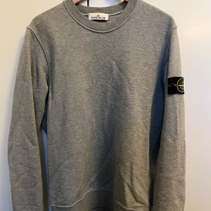 Grå Stone Island tröja - Tja, säljer denna tvärfeta och klassiska Stone Island tröja i grå färg💯👑 . Tröjan är i mycket bra skick utan några fläckar eller defekter och badgen är i bra skick. Hör gärna av er vid frågor 👑👑💯💯🤙