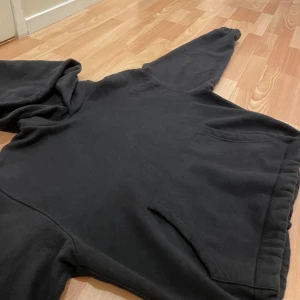 supertjock svart hoodie - Säljer en klassisk svart hoodie med luva och ficka framtill. Perfekt för en avslappnad stil. Den har långa ärmar och en bekväm passform. Jättetjock och oversized