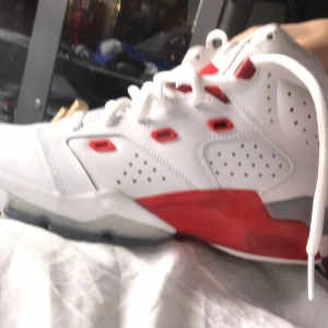 Vita och röda Nike Air Jordans - Snygga Nike Air Jordans i vitt och rött med klassisk Jumpman-logga på hälen. Skorna har snörning och en robust sula med röd och vit design. Perfekta för dig som vill ha en stilren och sportig look. Använda en gång säljer för 500 pris kan diskuteras. Och de är i storlek 40