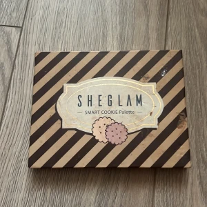 Ögonskuggspalett från Sheglam - Säljer en Sheglam Smart Cookie ögonskuggspalett med 12 olika nyanser. Paletten innehåller både matta och skimrande färger i jordnära toner som beige, brunt och rosa. Perfekt för att skapa både naturliga och mer dramatiska looks.