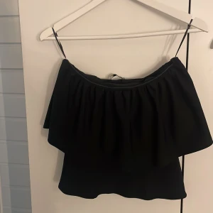 Svart offshoulder topp från Zara - Snygg svart offshoulder topp från Zara med volangdetaljer. Använd fåtal gånger 💞