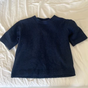 Mörkblå stickad tröja från Kappahl - Säljer en mörkblå stickad tröja från Kappahl i storlek 146/152. Tröjan har korta ärmar och en rund halsringning. Perfekt för en stilren och bekväm look. 🧶