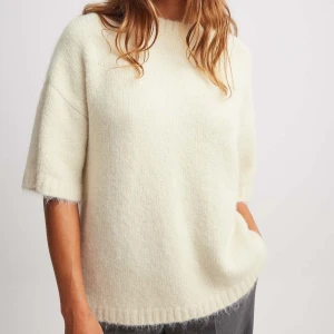 Vit stickad tröja - Intressekoll. Mysig vit stickad tröja med korta ärmar. Perfekt för en avslappnad stil med en bekväm passform. Tröjan har en enkel design med ribbade kanter vid ärmslut och nederkant. Knappast använd. Pris kan diskuteras 