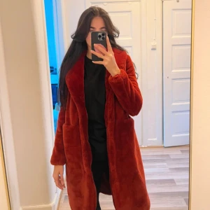 Röd teddyjacka - Säljer en mysig röd teddyjacka med lång ärm och normal passform. Perfekt för kyliga dagar och ger en trendig look. Jackan har en öppen design utan knappar eller dragkedja. 