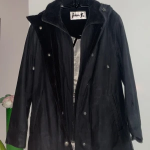 Blå  jacka från Johan Skoglund - Snygg blå  jacka från Johan Skoglund med dragkedja och knappar. Jackan har en stilren design med snörning i kragen och en slitsdetalj. Perfekt för kyligare dagar.