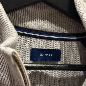 Grå stickad tröja från GANT - GANT Cotton/Wool Ribbed Half Zip Sweater Grey Melange, Storlek XL. Sällan använd, väldigt fint skick