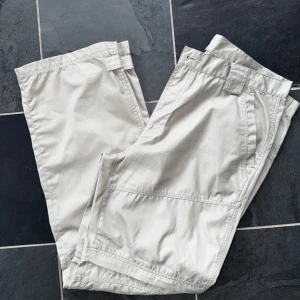 Beige cargopants med avtagbara ben - Snygga beige cargopants med praktiska fickor och avtagbara ben för en flexibel stil. Perfekta för utomhusaktiviteter och äventyr. Byxorna har knappar och dragkedja i midjan. Kika och se om du ser något mer i min profil som du gillar så skickar jag med det till dig också!😊 Fler kläder kommer! 