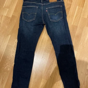 Levi's 502 jeans - Säljer ett par klassiska Levi's 502 jeans i mörkblå denim. De har en straight passform med fem fickor och knappgylf. Perfekta för en avslappnad stil.