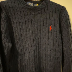 Ralph Lauren Cotton Sweatshirt- Mörkblå-Helt Ny- Perfekt Skick - Helt ny och oanvänd Ralph Lauren sweatshirt i strilen mörkblå färg. Tillverkad i 100% mjuk bomull för hög komfort och långt hållbarhet. Perfekt för både vardag och finare tillfällen med den enkla, eleganta design. Passa på att göra ett fynd på denna klassiska tröja till ett bättre pris än nypriset. Den säljs snabbt tveka inte!