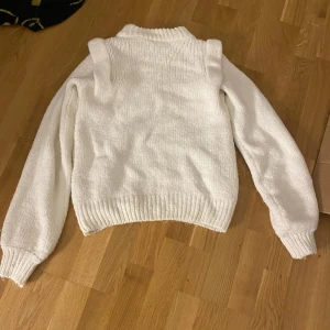 Vit stickad tröja - Mysig vit stickad tröja med ribbade muddar och hög krage. Perfekt för kyliga dagar då den är väldigt varm. Endast använd 1 gång då den inte riktigt är i min stil. Tröjan är i stl xs men passar även s