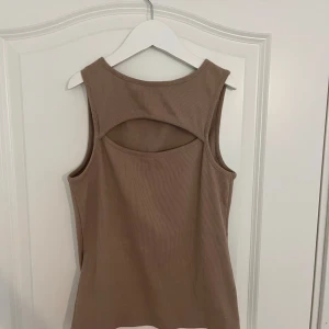 Beige/brun ribbad linnetopp från NLY Trend - Snygg beige/brun ribbad linnetopp från NLY Trend med ett unikt utskuret mönster. Passar bra till både jeans och kjol. 🤎