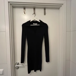 Svart ribbad klänning från NA-KD - Snygg svart ribbad klänning från NA-KD i storlek medium med långärmad design och krage. Passar även smal då klänningen har en tight passform. Endast använd en gång. Perfekt nu inför julen!🫶🏼