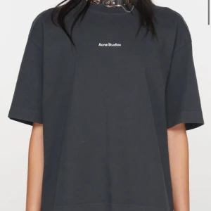 Mörkgrå t-shirt från Acne Studios - Snygg svart t-shirt från Acne Studios med enkel design och logga på bröstet. Perfekt för en stilren look.