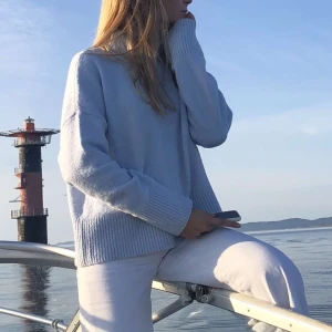 Ljusblå stickad tröja & Other Stories - Mysig ljusblå stickad tröja med långa ärmar och ribbade detaljer vid ärmslut och nederkant. Perfekt för kyliga dagar vid havet eller en avslappnad dag hemma.