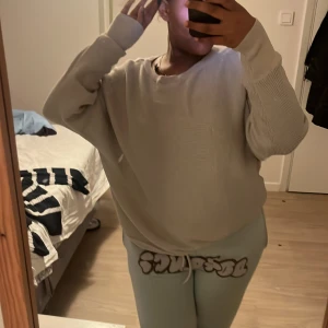 Beige glittrig tröja från Kappahl - Säljer en beige glittrig tröja från Kappahl i storlek M. Tröjan har en avslappnad passform med långa ärmar och rund halsringning. Perfekt för att lägga till lite glitter i vardagen!