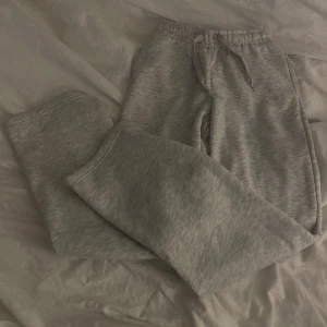 Grå mjukisbyxor från Gina Tricot (basic straight sweatpants, oanvända) - Säljer ett par grå mjukisbyxor från Gina Tricot. Fickor på sidorna, Storlek XS, super mjukt material inuti, sitter snyggt på. Pris lappen är fortfarande på, helt oanvända. 