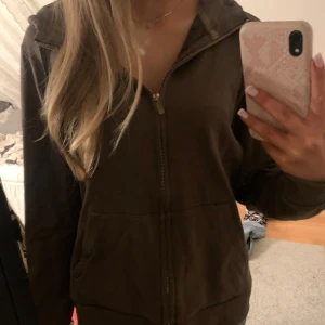 Brun huvtröja med dragkedja - Säljer en brun huvtröja i storlek M. Tröjan har en dragkedja framtill och justerbara snören i huvan. As najs passform.🩷