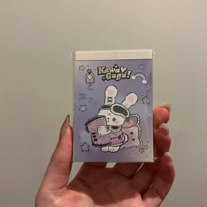 Kawaii Gugu anteckningsblock - Sött anteckningsblock med Kawaii Gugu-design. Framsidan pryds av en gullig kanin med sovmask och kudde. Perfekt för att skriva ner dina tankar eller idéer. Kompakt storlek som är lätt att ta med sig. Med klistermärken längst bak