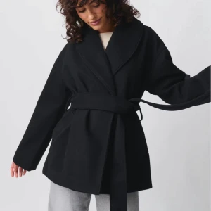 Svart kappa med bälte - Säljer min svarta kappa från Gina Tricot, använd endast en gång. Perfekt nu inför vintern och kyligare dagar. Nypris: 699, säljes för 490 kr.