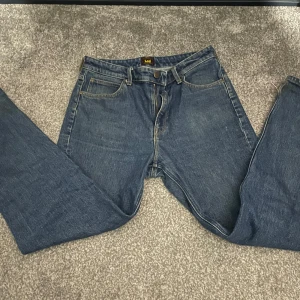 Blå jeans från Lee - Säljer ett par klassiska blå jeans från Lee. De har en straight passform med fem fickor och en dragkedja. Perfekta för en avslappnad stil.