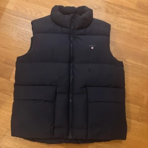Marinblå dunväst från Gant - Helt ny Gant väst aldrig använd. Är en barn stolek men passar en med XS (jag är 160cm). 