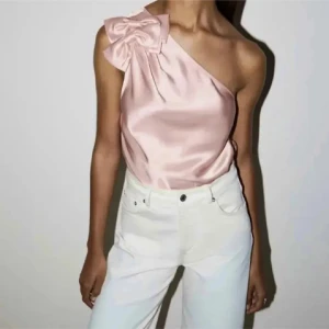 Rosa oneshoulder-top med rosett - Supersnygg rosa oneshoulder-top i satin med en stor rosett vid axeln. Från & other stories 