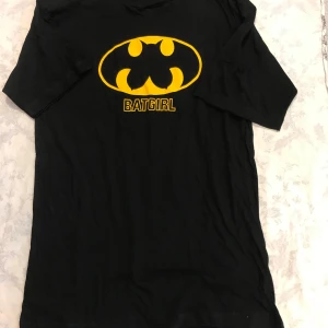  Batman Girl t-shirt - Cool svart t-shirt med Batgirl-logga i gult på framsidan. Perfekt för alla superhjältefans! T-shirten har korta ärmar och är gjord i ett bekvämt material. Stlk kvar M, L ,XL       99kr/st , finns fler kvar, samma frakt , helt ny 