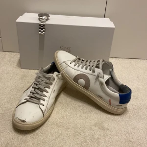 Vita Oliver Cabell skor - Säljer nu dessa feta Oliver Cabell sneakers med en originell sliten look . Skorna är vita med blå baksida och grå snören som matchar med loggan i mocka. Perfekt för vardagen och för uppklädda event. Skorna är i 8/10 skick. Orginalpris 2299kr + Dyr frakt och tull. Skriv vid minsta lilla fundering.