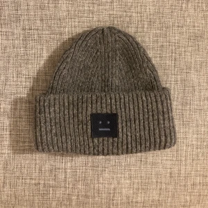 Acne mössa  - Snygg grå acne mössa med en enkel design. Perfekt för kyliga dagar och ger en stilren look. Passar bra till både vardag och mer avslappnade tillfällen. Nypris: 1700kr
