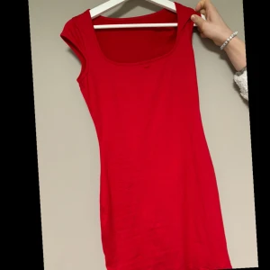 Röd ärmlös klänning - Snygg röd ärmlös klänning med en enkel och stilren design. Perfekt för en somrig dag eller en kväll ute. Klänningen har en smickrande passform och är gjord i ett mjukt material. Aldrig använd