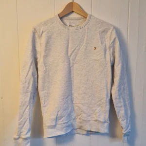 Grå sweatshirt från Farah - Stilren grå sweatshirt från Farah i storlek XS. Tröjan har en liten broderad logga på bröstet och är tillverkad av 100% bomull.