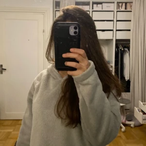 Grå hoodie från Gina Tricot - Mysig grå hoodie i fleece från Gina Tricot. Perfekt för kyliga dagar med sin mjuka och varma känsla. Den har en klassisk huva och en avslappnad passform.världens mysigaste 