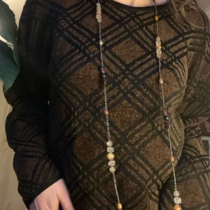 Brun och svart mönstrad tröja - Säljer en brun och svart tröja med rutigt mönster. Tröjan har långa ärmar och en avslappnad passform, perfekt för kyligare dagar. Storlek S men upplevs större.