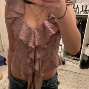 Rosa volangtopp - Säljer en söt rosa volangtopp med  v-ringning och volanger framtill. Använd en gång så den är som ny!❤️