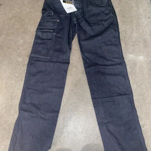 Mörkblå cargopants - Snygga mörkblå cargopants med flera praktiska fickor. Perfekta för en avslappnad stil med en touch av funktionalitet. Byxorna har en rak passform och är tillverkade i ett slitstarkt material.