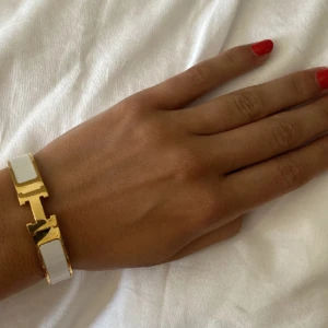 Intressekoll H armband - Elegant armband i vitt och guld med en stilren design. Perfekt accessoar för att lyfta vilken outfit som helst. Armbandet har en glänsande finish och en unik låsdetalj. Intressekoll!!! Säljer endast vid bra bud! OBS: bilderna är mina! Osäker på om den är äkt@, man får bedöma själv!