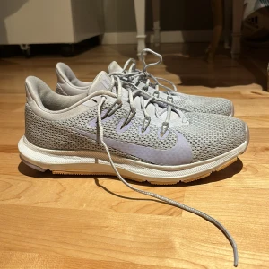 Grå Nike sneakers.  - Säljer ett par grå Nike sneakers med snörning och en stilren design. Skorna har en mesh-ovandel för bra ventilation och en slitstark sula med bra grepp. Perfekta för både träning och vardag. PRIS kan diskuteras!