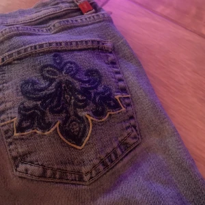 Jeans m broderade fickor  - Köpta från plick men kommer inte till användning Uppsydda men inte avklippta så går nog bra att sprätta upp om man vill Se bilder för mindre defekter. (Inte hål på sista bilden)  Ytterben(uppsytt) 90cm Ytterben(vanligt) ca 101cm Innerben(uppsytt) ca 64 cm Innerben(vanligt) 74cm Midja rakt över 36cm Grenhöjd Ca 25cm