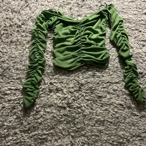 Grön långärmad topp från Amisu - Snygg grön topp från Amisu med långa ärmar och rynkdetaljer. Perfekt för att ge en trendig touch till din outfit. Tillverkad i ett mjukt och bekvämt material.