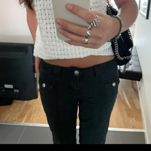 Hm svarta jeans  - Snygga svarta jeans med låg midja och utsvängda ben. Jeansen har dekorativa knappar på fickorna och en stilren design. Jag är 168 som preferens. Storlek: 36 passar mig som har xs/s!💞