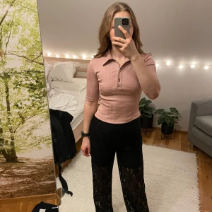 Rosa topp från nakd - Rosa ribbad tight T-shirt topp med knappar från nakd i storlek S.