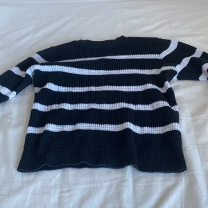 Svart och vit randig tröja - Säljer en svart och vit randig tröja med långärmade ärmar. Tröjan har ett klassiskt randigt mönster och är perfekt för både vardag och avslappnade tillfällen.