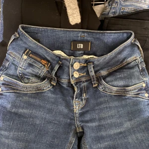 Blå jeans från LTB - Snygga blå jeans från LTB med klassisk femficksdesign och dubbla knappar i midjan. Jeansen har en stilren look med kontrastsömmar och en bekväm passform. Det är modellen straight på byxorna. XS längden passar för folk som är 155