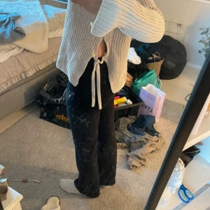 Beige stickad tröja från Hunkydory - Säljer en snygg beige stickad tröja från Hunkydory. Tröjan har långa ärmar och en unik design med knytband i sidorna. Perfekt för en stilren och bekväm look.