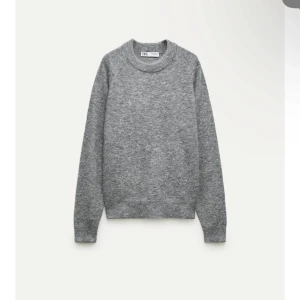 Grå stickad tröja från Zara - Snygg och enkel grå stickad tröja från Zara. Tröjan har långa ärmar och en klassisk rund halsringning.