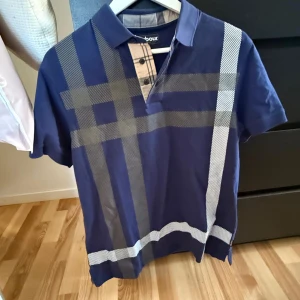 Barbour piké  - Säljer en blå piké från Barbour med  rutigt mönster. Storlek Medium. Nypris 1600kr.