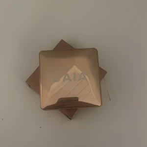 Highlighter från GAIA - Elegant highlighter i en lyxig guldskimrande förpackning med inbyggd spegel. Perfekt för att ge ansiktet en strålande lyster. Kompakt design som är lätt att ta med i väskan.