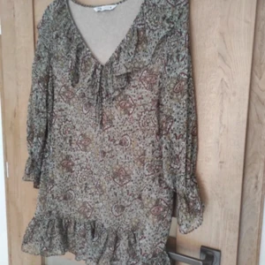 Mönstrad klänning från Zara - Säljer en mönstrad klänning från Zara med volangdetaljer och v-ringning.  Perfekt för höst och vår!