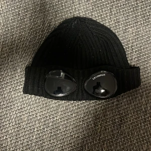 Svart stickad mössa från C.P. Company - Den är i nyskick den är använd ca 4 gånger .ny pris 1500. Pris kan diskuteras 